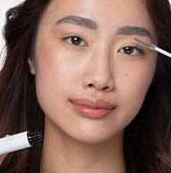 A woman is focused on applying makeup with a brush